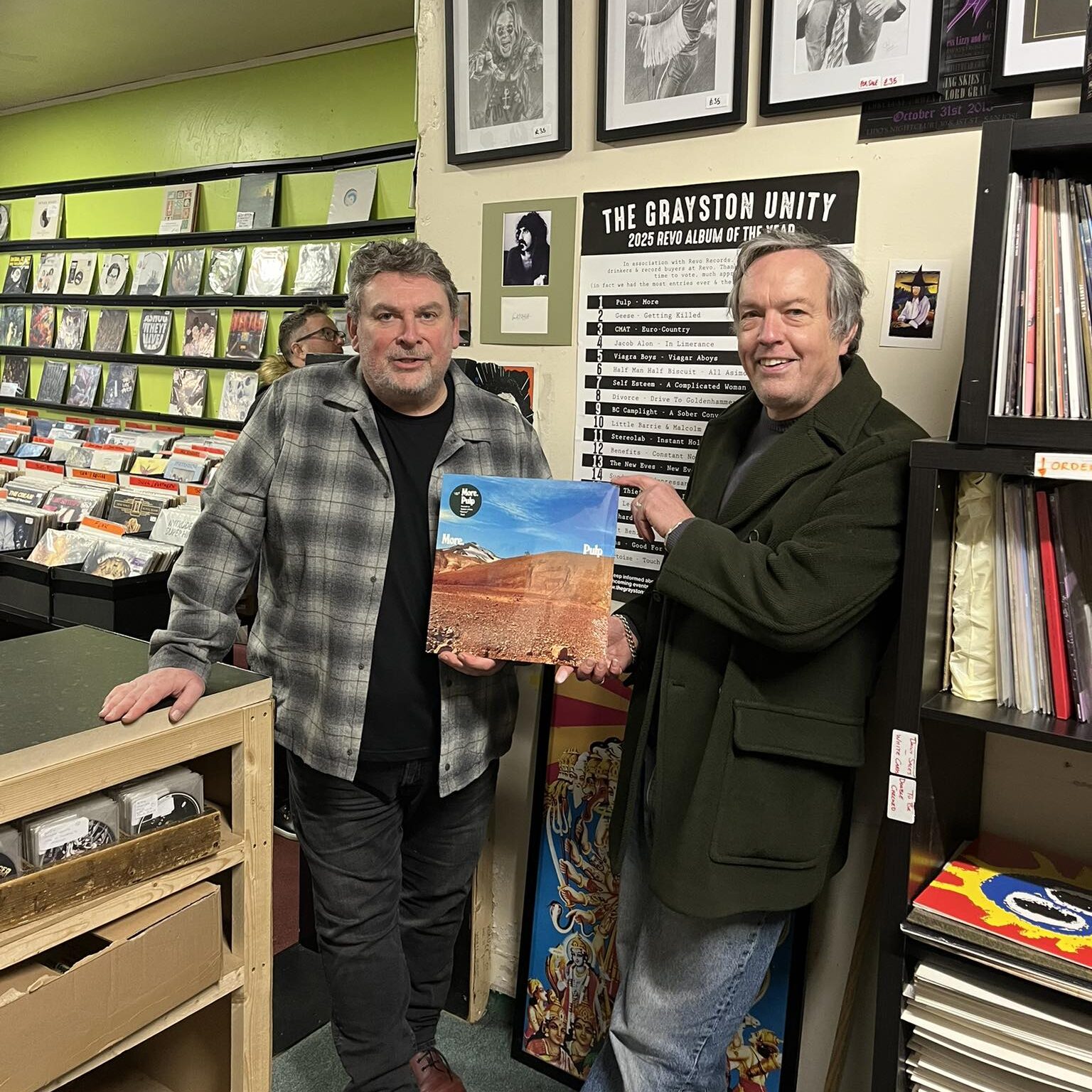 Ade the manager of Revo and Michael from The Grayston Unity holding the record voted album of the year for 2025